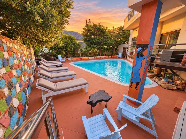 Pool courtyard, loungers and African artwork at sunset